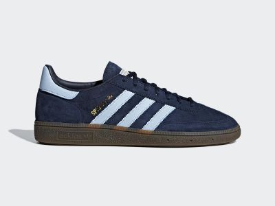 A pair of navy blue and white Adidas sneakers with a gum sole, set against a plain light background.