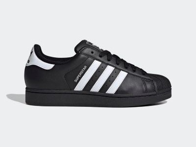 A pair of black and white Adidas Superstar sneakers with the iconic three-stripe design, set against a plain white background.
