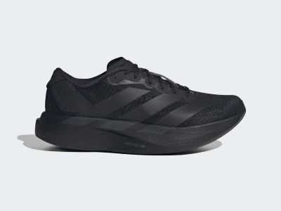 A black athletic shoe with a thick, curved sole is the focus of the image, set against a plain, light-colored background.