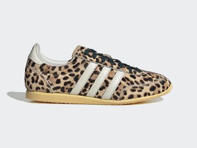 A pair of leopard-print sneakers with white stripes and a tan sole against a plain white background.