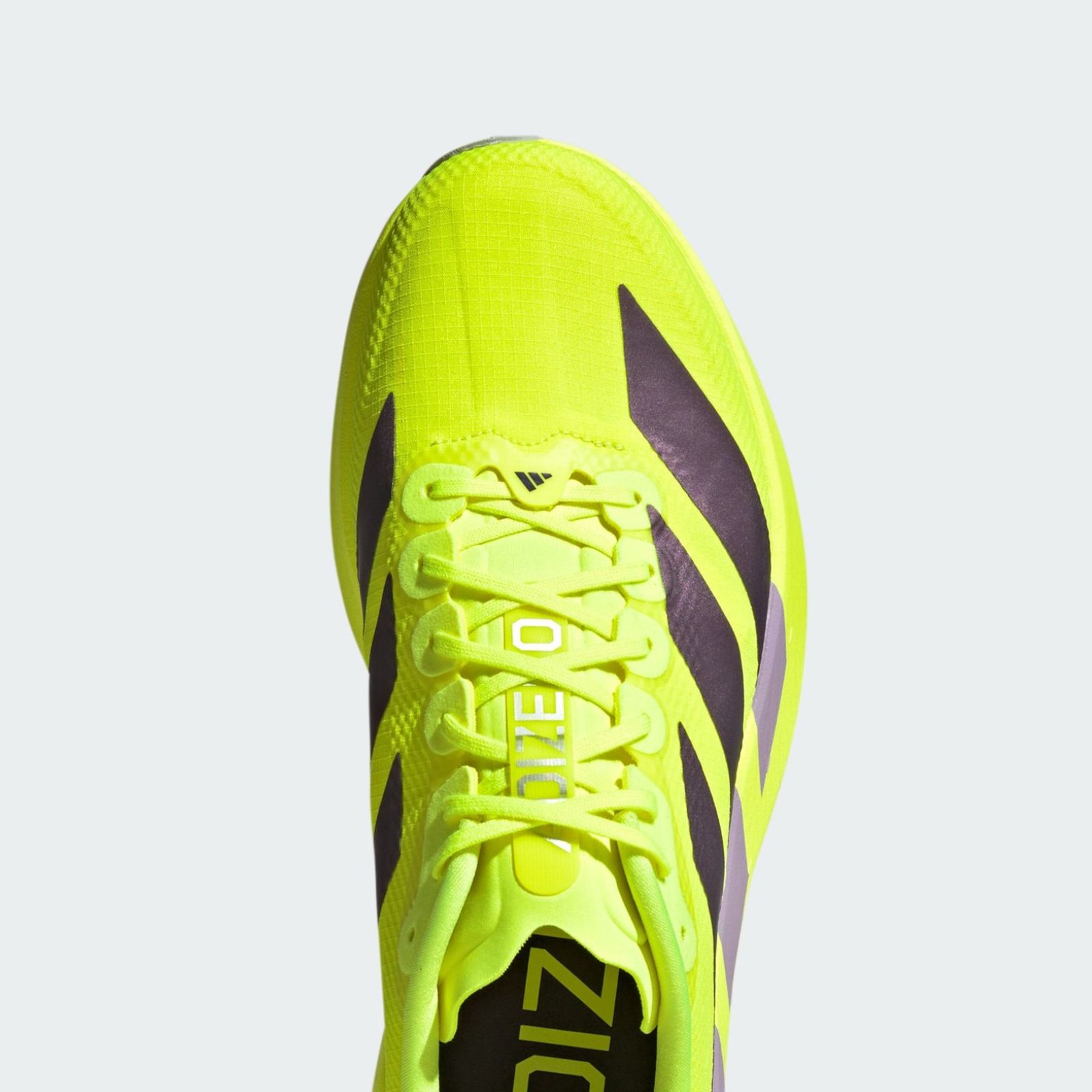 A bright neon yellow and black athletic shoe with laces and treads, against a plain white background.