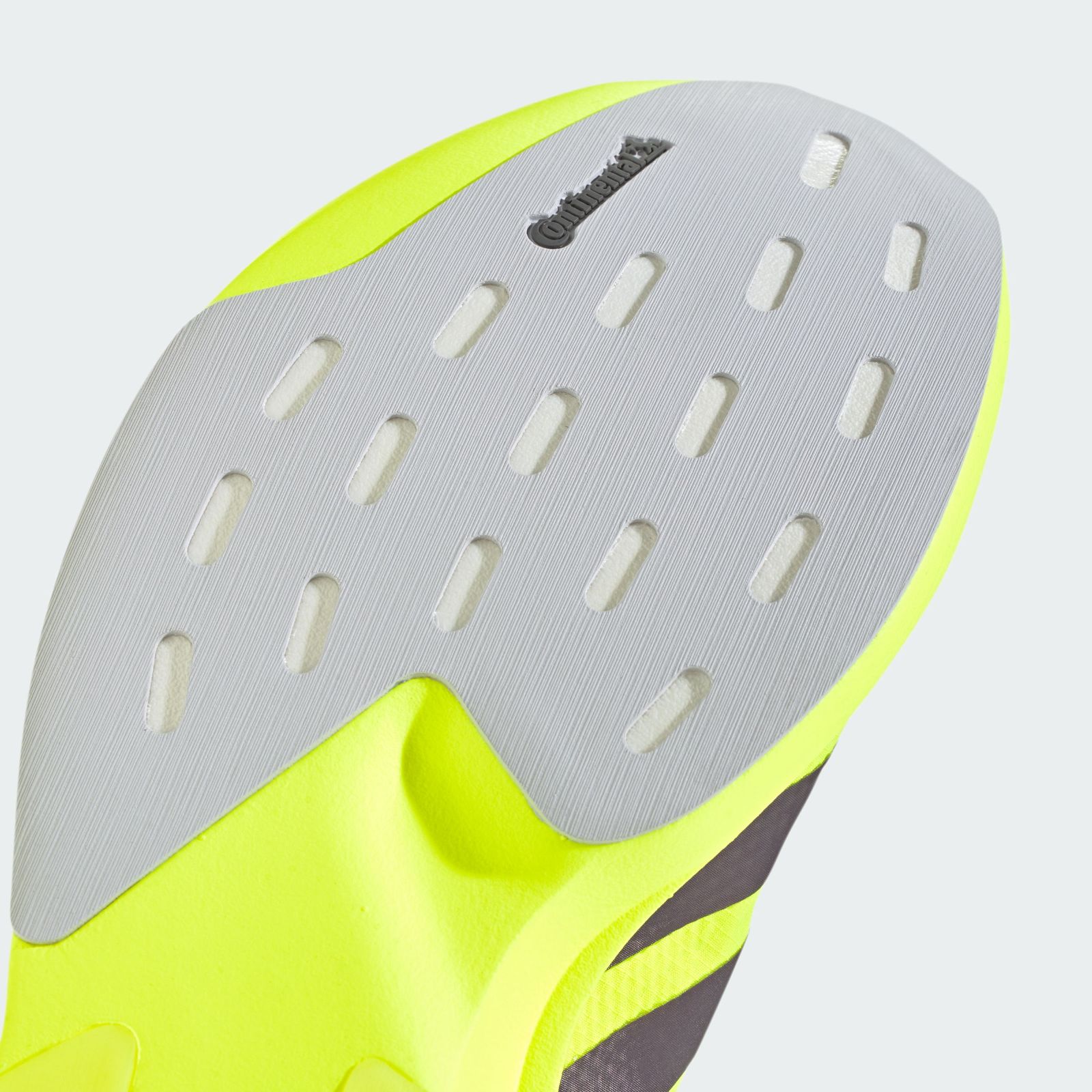 A gray and yellow sports shoe with a perforated design and a prominent logo on the side.