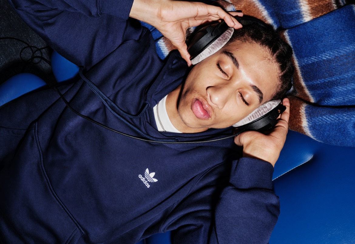 A person wearing a navy blue jacket appears to be sleeping peacefully on a blue and white blanket or surface.