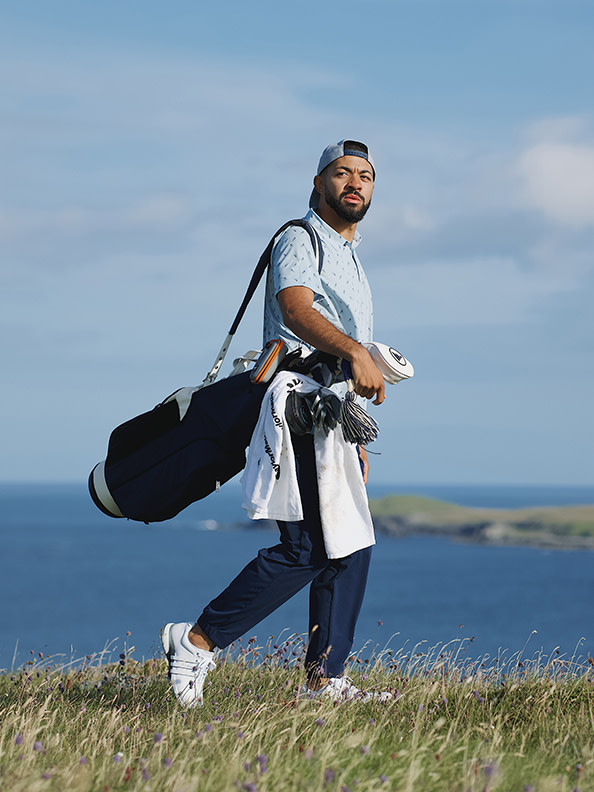 Man swings golf club.