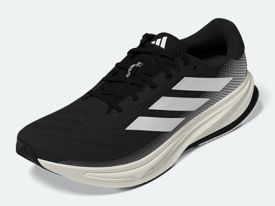 A black and white athletic shoe with a sleek, modern design sits on a plain white background.