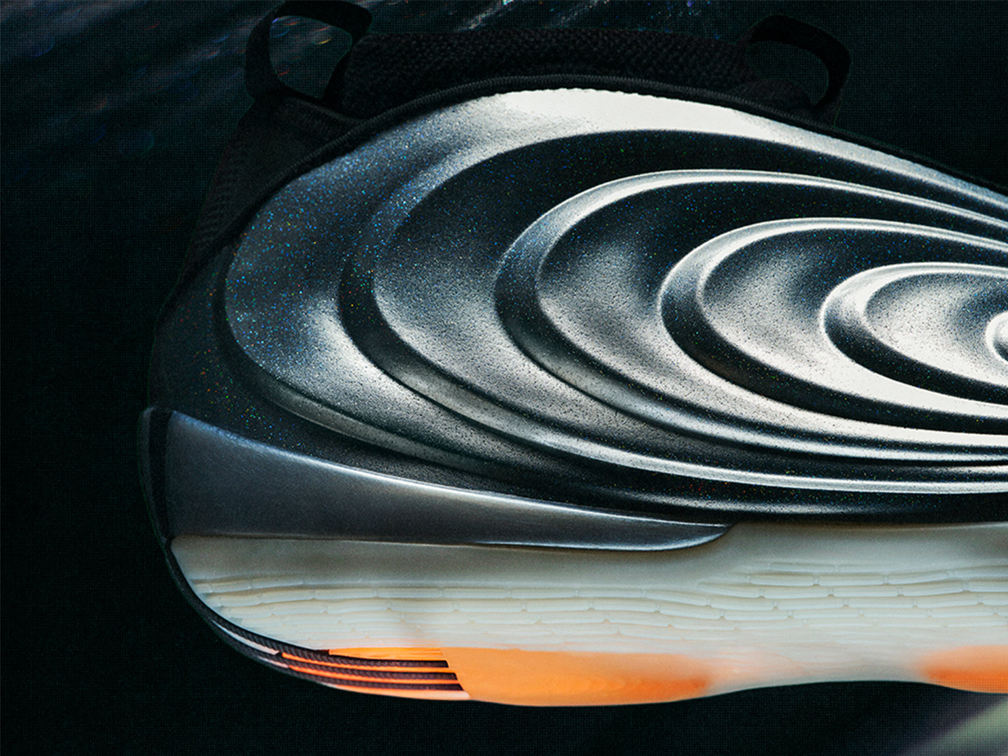 The image depicts a close-up view of a series of concentric, curved metal or plastic forms, creating a striking visual pattern against a dark background.