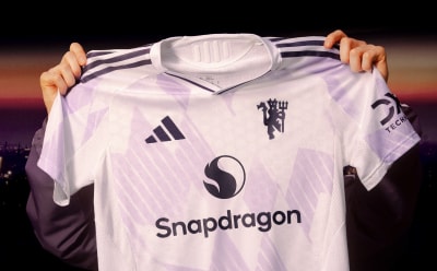 A white soccer jersey with the Snapdragon logo prominently displayed, set against a dark background with hints of color.