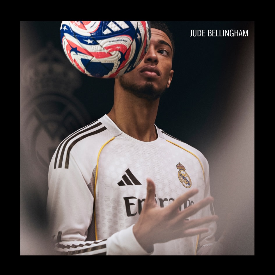 A young man wearing a white soccer jersey with the Real Madrid logo, holding a soccer ball with a Union Jack design on his head.