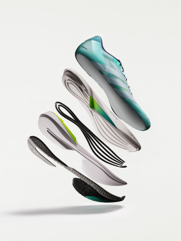 A pair of modern, lightweight running shoes in shades of gray, black, and teal, with a sleek, streamlined design, appear to be floating against a plain white background.