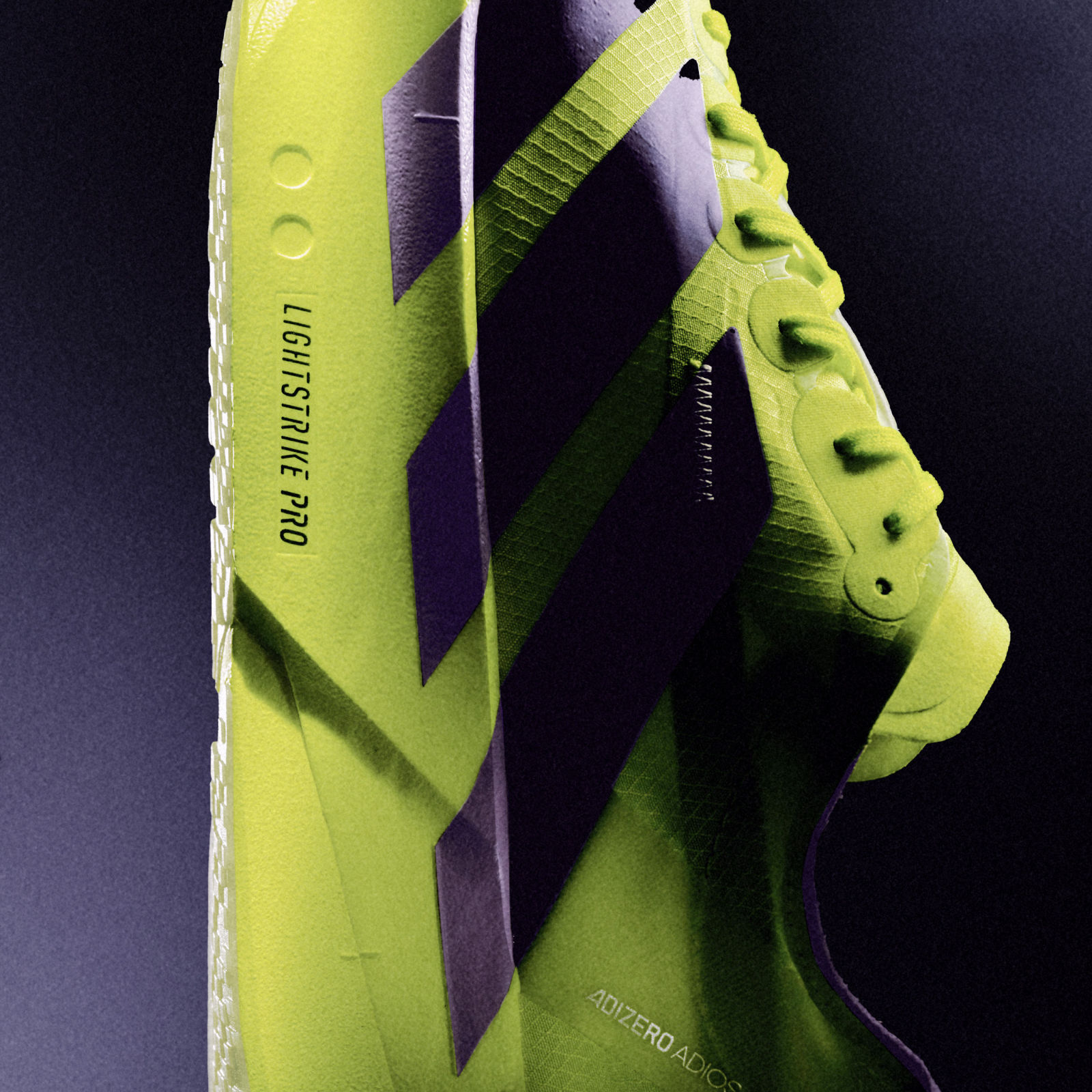 The image shows a pair of bright green and purple athletic shoes with distinctive branding and design elements.