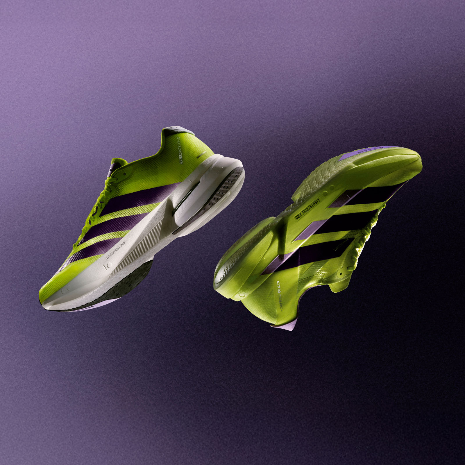 Two vibrant green and white athletic shoes are suspended against a deep purple background, creating a striking visual contrast.