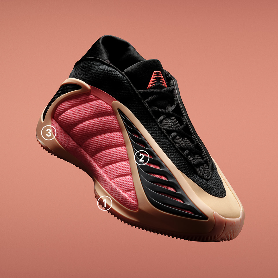 A pair of futuristic-looking sneakers with a black and pink color scheme, set against a peach-colored background.