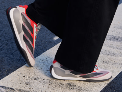 The image shows a pair of red and white athletic shoes on a concrete surface.