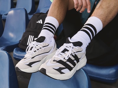 Close-up image of legs in adidas footwear.