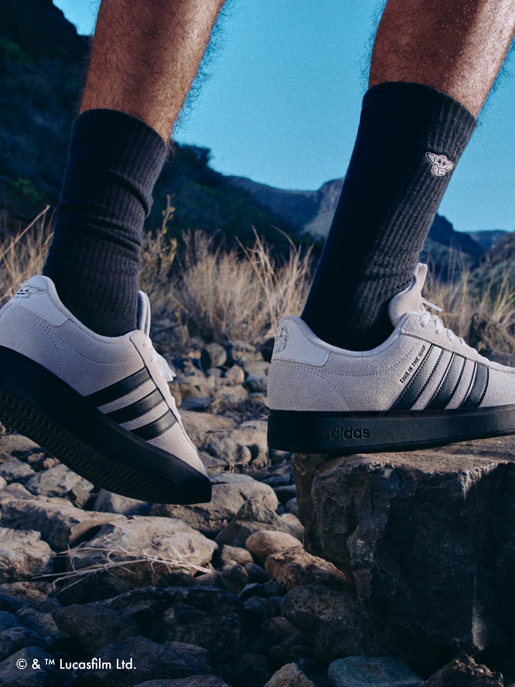 Close up of adult’s footwear stepping onto a rock, wearing the adidas | Star Wars: The Mandalorian™ collection