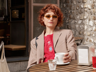 Woman having coffee while wearing FC Bayern Munich lifestyle jersey