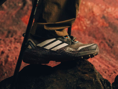 Close-up of Skychaser GTX shoe on top of a rock with trekking sticks visible.