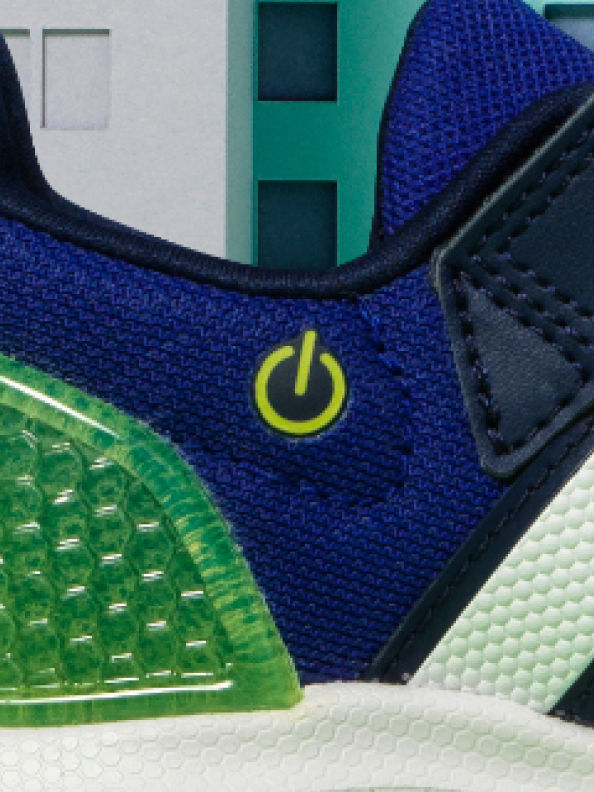 화이트와 그린 배경과 대비된 측면의 파워 버튼 아이콘이 돋보이는 블루와 그린 컬러의 운동화
