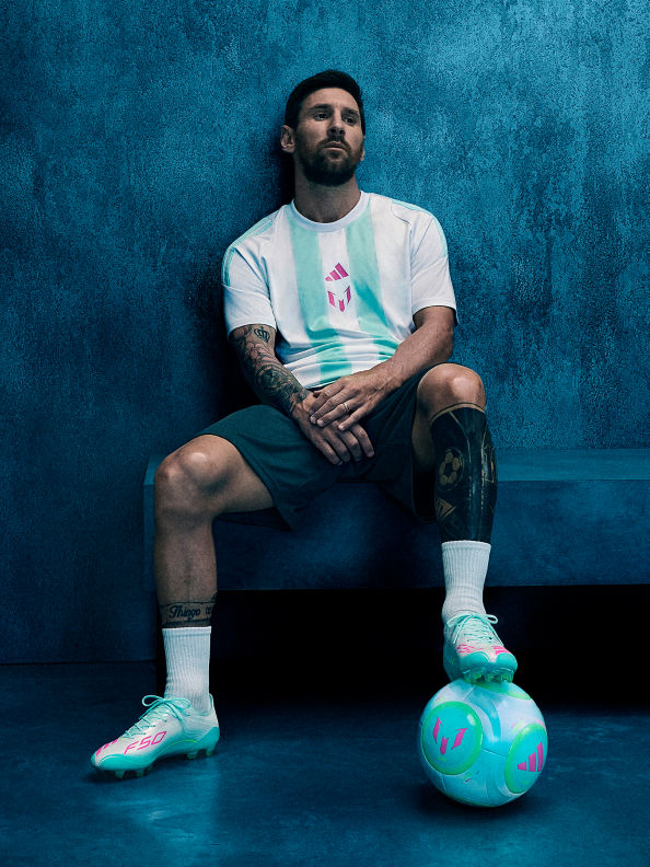 Lionel Messi ngồi trên băng ghế trong phòng thay đồ trong studio rực sáng, trong bộ sưu tập adidas mới.