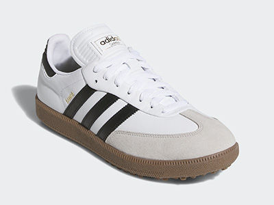 Un paio di sneaker adidas bianche e nere con suola in gomma, su uno sfondo bianco.