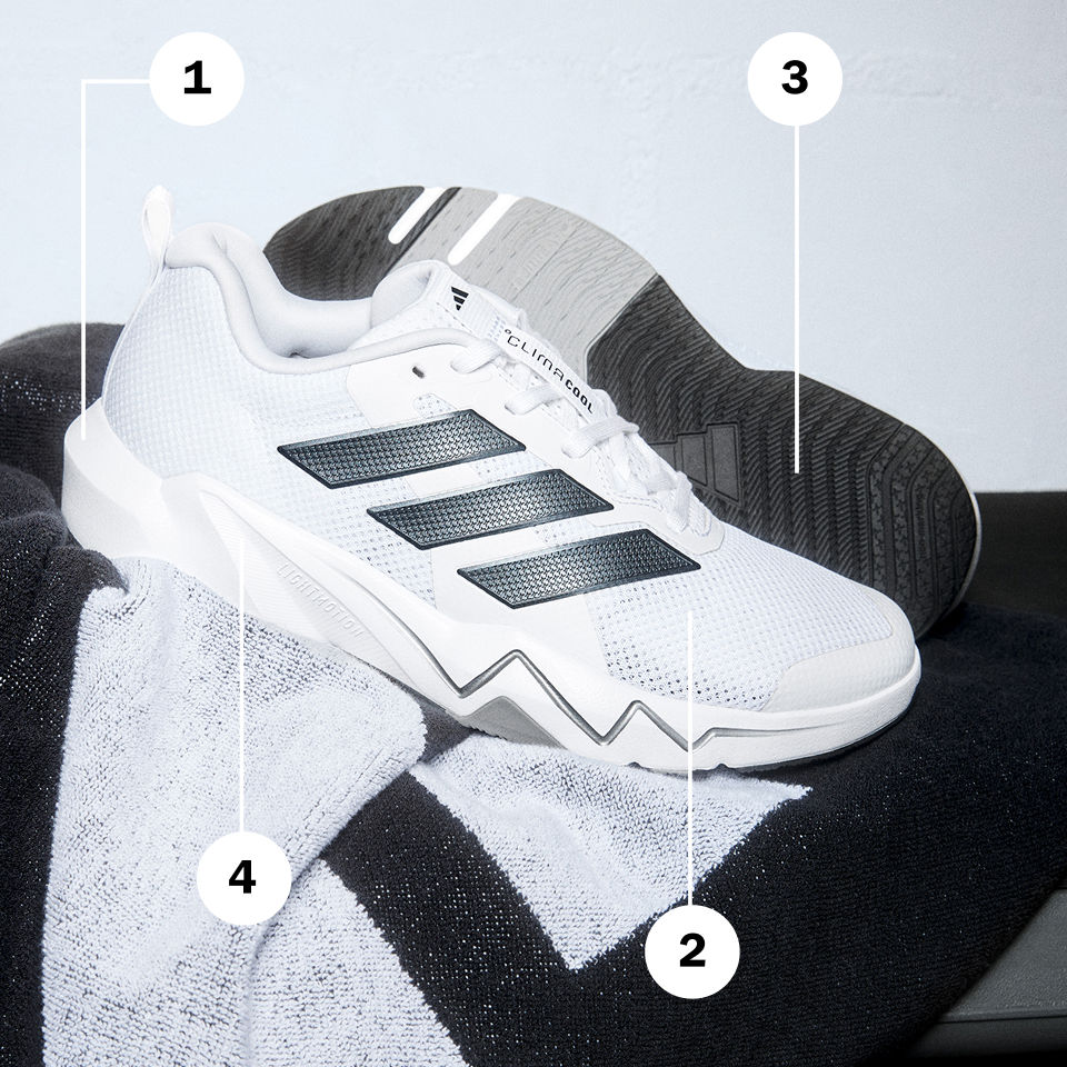 A white and black athletic shoe with distinctive design elements sits on a dark background.