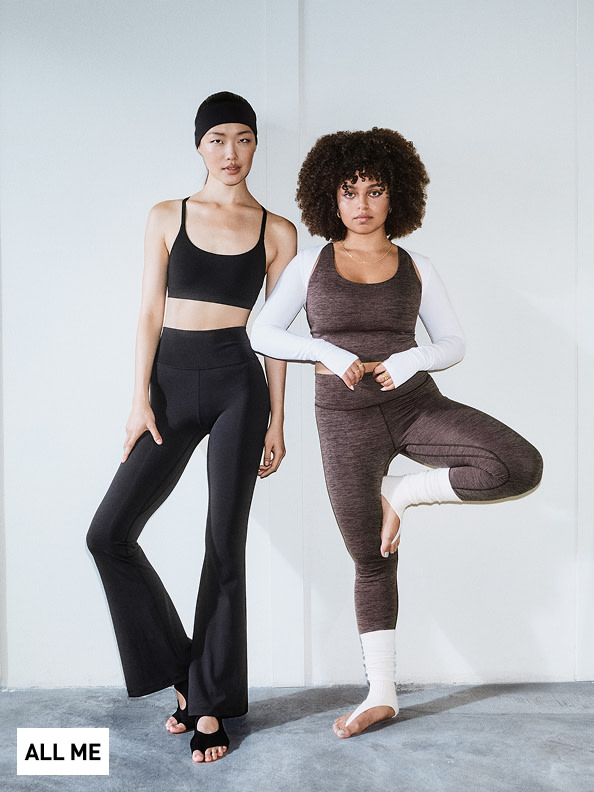 Dos mujeres con ropa deportiva, una con pelo negro liso y la otra con pelo oscuro rizado, posan sobre un fondo liso.