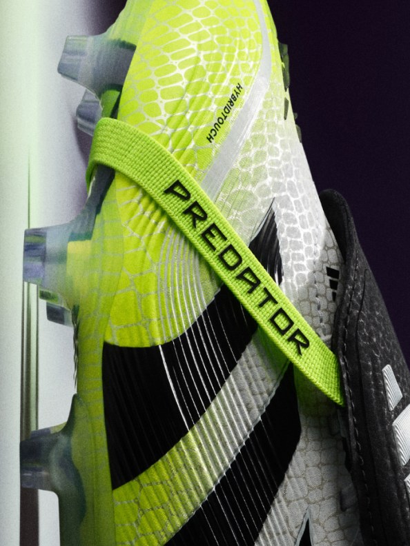 A close-up view of a bright yellow and black athletic shoe with the "Predator" logo prominently displayed on the side.