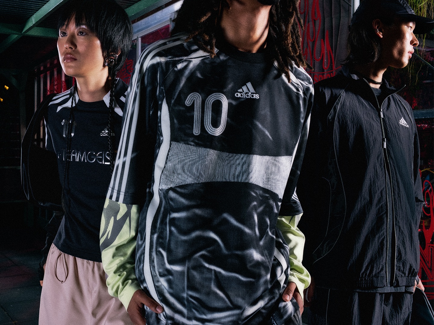 The image shows three individuals wearing Adidas sportswear, including a jersey with the number 10, standing in what appears to be a locker room or similar indoor setting.