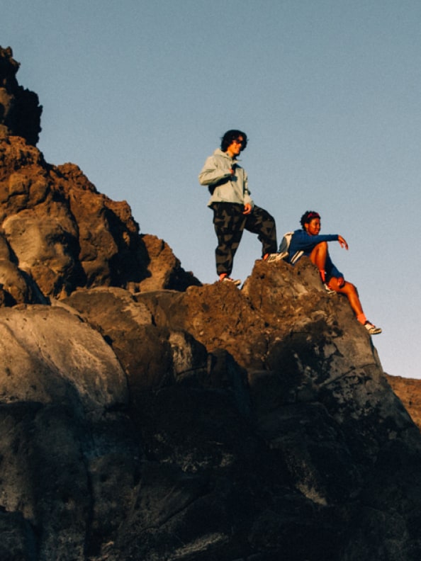 Group of hikers sitting on rocky precipice wearing adidas Terrex hiking gear and Skychaser shoes.