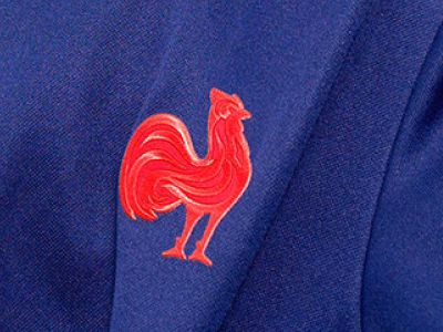 Et farverigt rødt hanemærke vises tydeligt på en marineblå stofbaggrund.