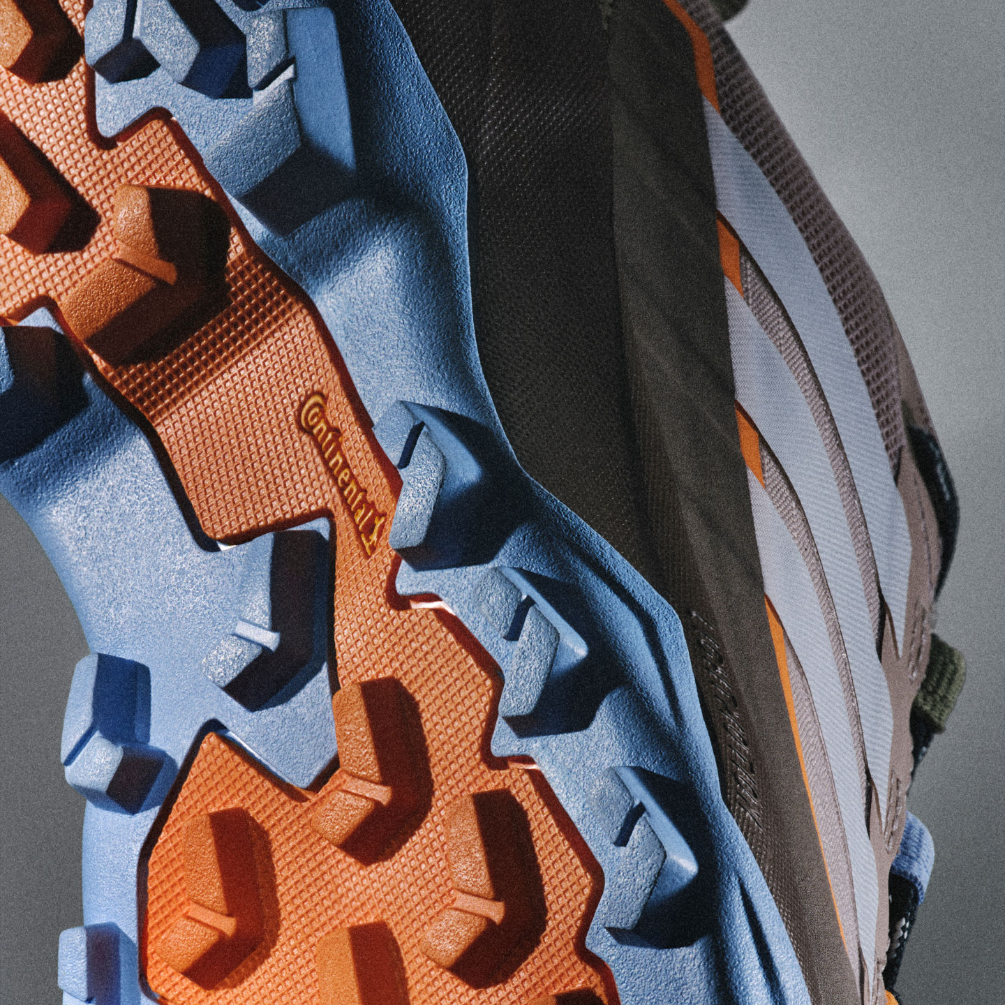 La imagen muestra un primer plano de varias texturas y patrones de tela, incluidos tonos azules, naranjas y negros, que crean una composición abstracta y visualmente interesante.