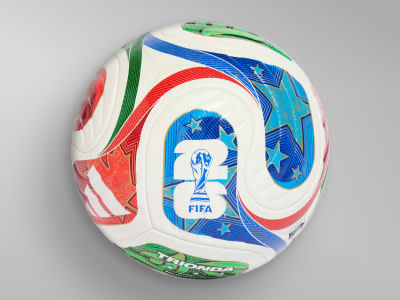 A colorful and vibrant soccer ball with the FIFA logo and various geometric patterns and shapes in shades of red, blue, and green against a light background.