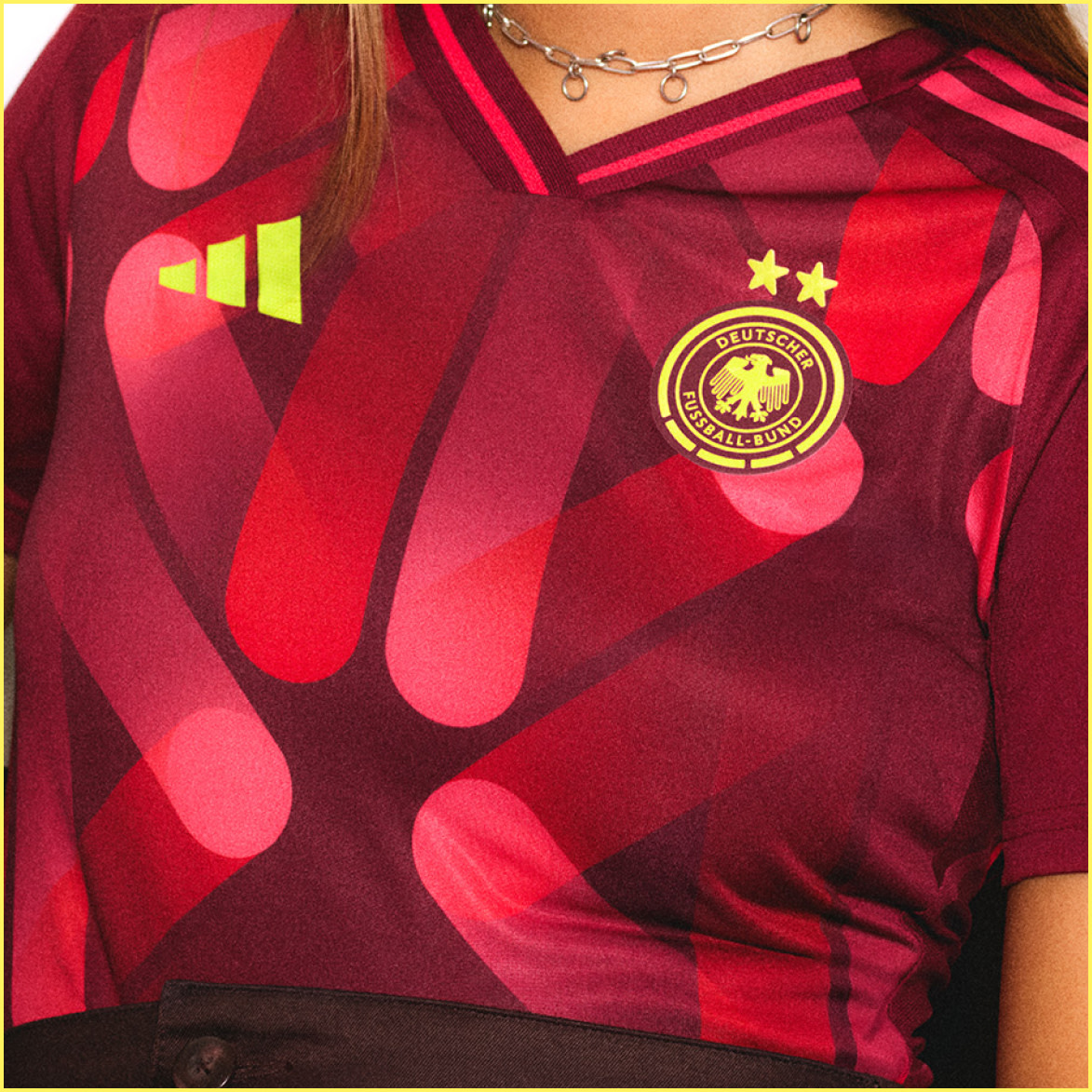 Žiarivý červeno-žltý dres s erbom a hviezdami na vzorovanom pozadí.