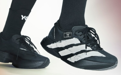 Ein schwarz-weißer Sportschuh mit Schnürsenkeln vor einem schlichten Hintergrund.