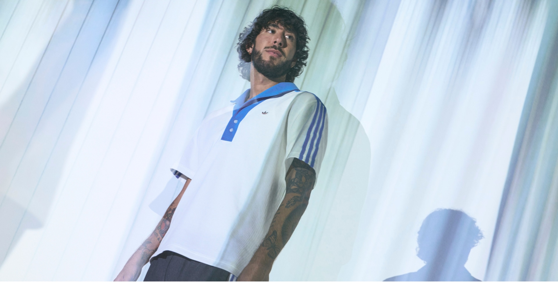 Model wears white adidas t-shirt with blue collar
