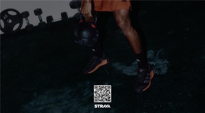 A person wearing dark clothing stands in a dimly lit environment, with a QR code prominently displayed in the foreground.