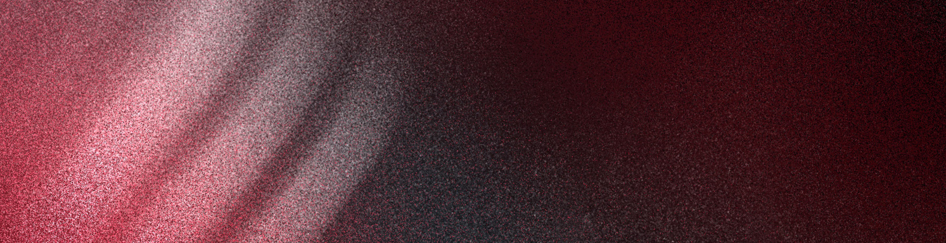 The image appears to be a close-up view of a dark, textured surface with a gradient of colors ranging from deep burgundy to black, creating a moody and atmospheric visual effect.