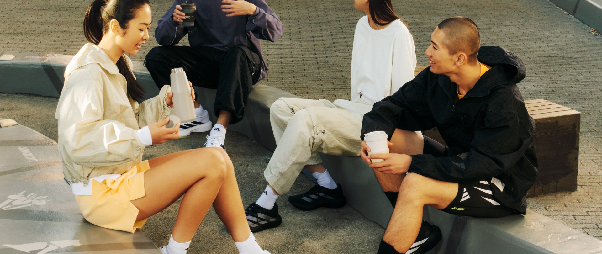 The image depicts a group of individuals, some wearing black and white clothing, engaged in what appears to be a social or professional gathering, with the background suggesting an indoor setting.