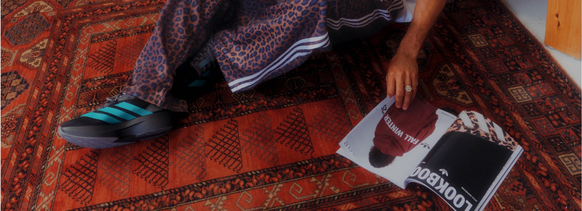 The image features a vibrant, patterned fabric with a leopard print design, along with a book or magazine with a bold, graphic cover.