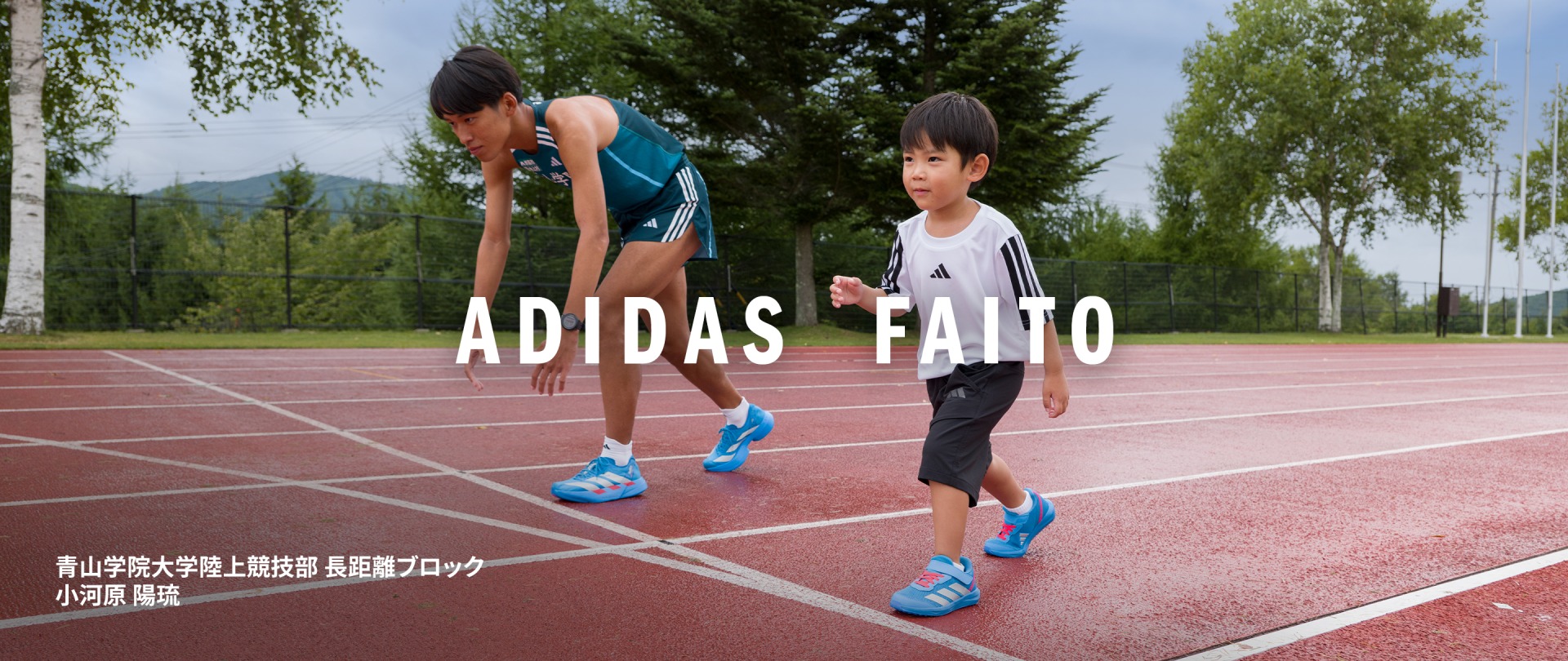 Two young athletes, a boy and a girl, are standing on a running track wearing Adidas sportswear. The background features lush greenery and trees, suggesting an outdoor sports facility.