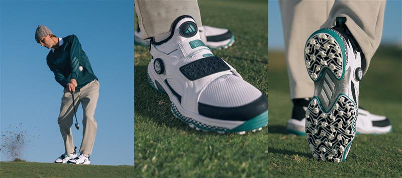 The image shows a close-up view of a golf shoe with a white and teal design, resting on a grassy field with a golfer in the background wearing a green jacket and holding a golf club.