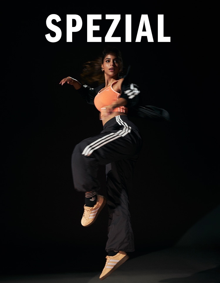 A person wearing an orange top and black pants is performing a dynamic dance move against a dark background with the word "SPEZIAL" prominently displayed.