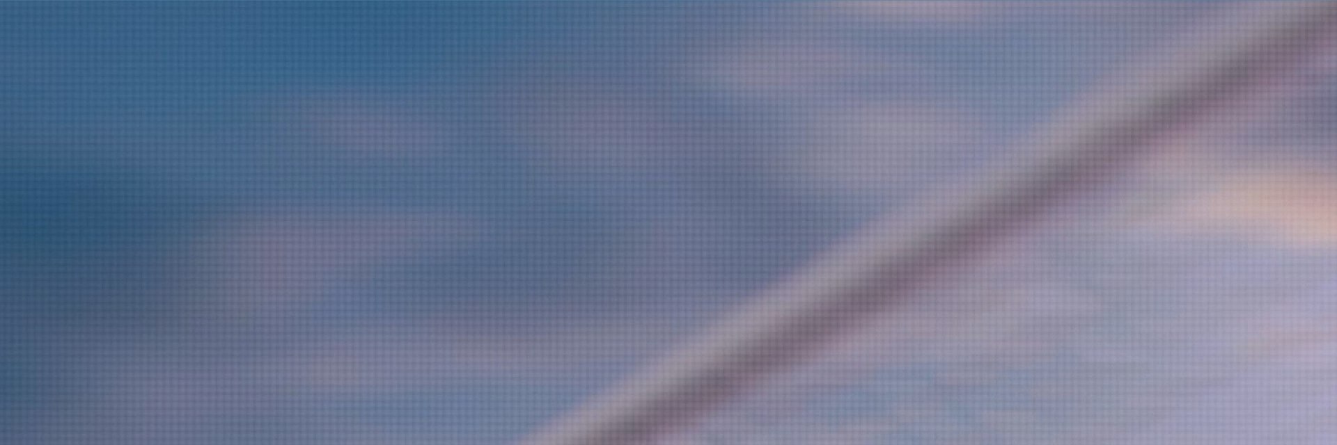 The top part of a soccer goal in front of a blurred blue backdrop.