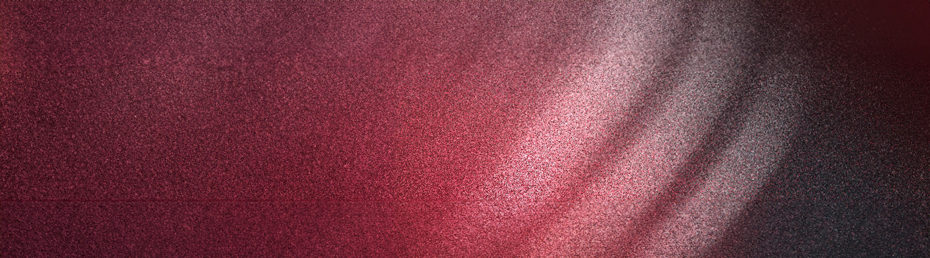 A vibrant, textured gradient of deep red and burgundy hues fills the frame, creating a visually striking and captivating abstract composition.