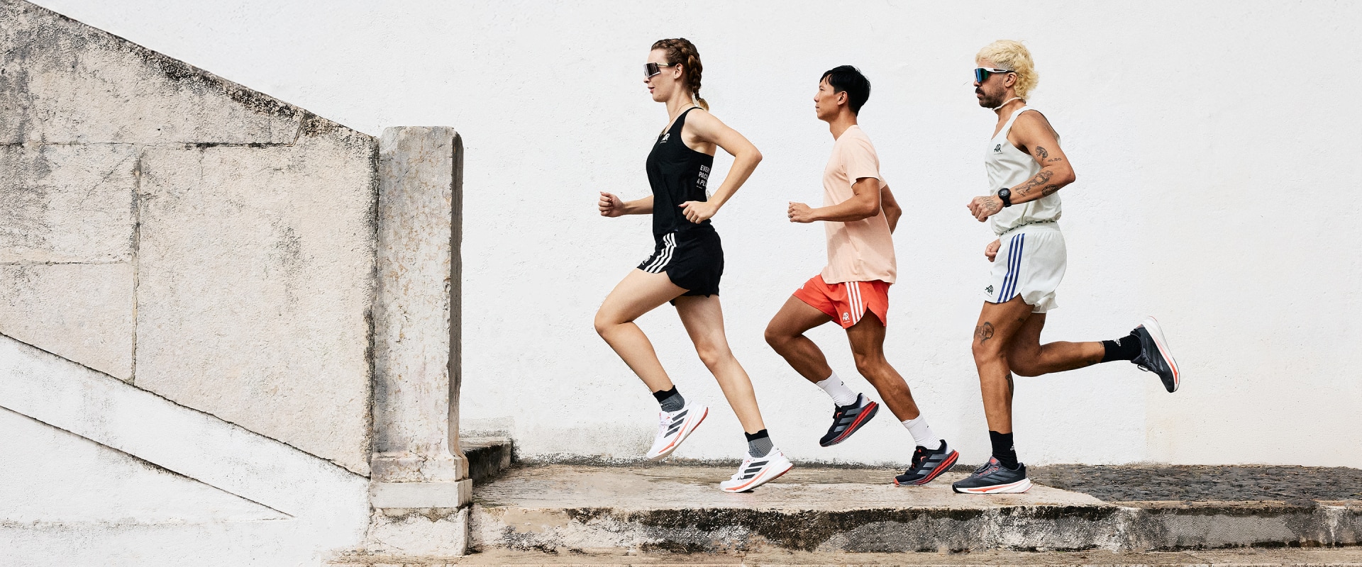 Three people running together in a line, one woman and two men, in the new adidas Runners collection