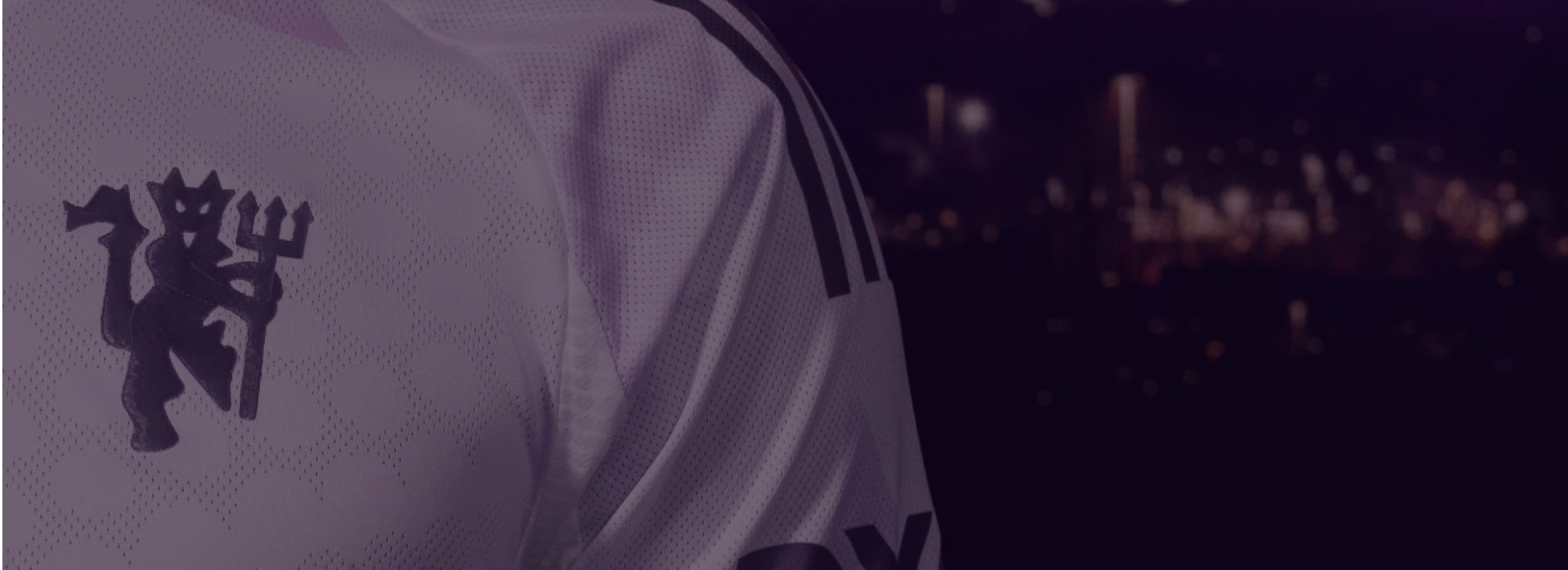 Uma camisola de desporto branca, com o número 5 e a palavra "ADIDAS" em destaque, sobre um fundo escuro e desfocado.