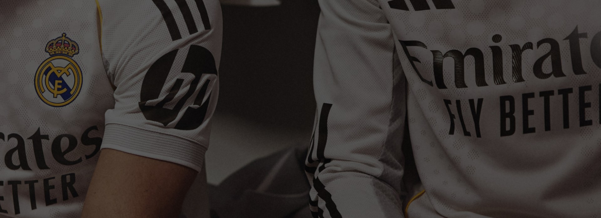 The image shows a close-up view of a person wearing a white sports jersey with black stripes and text, standing in a dark background.