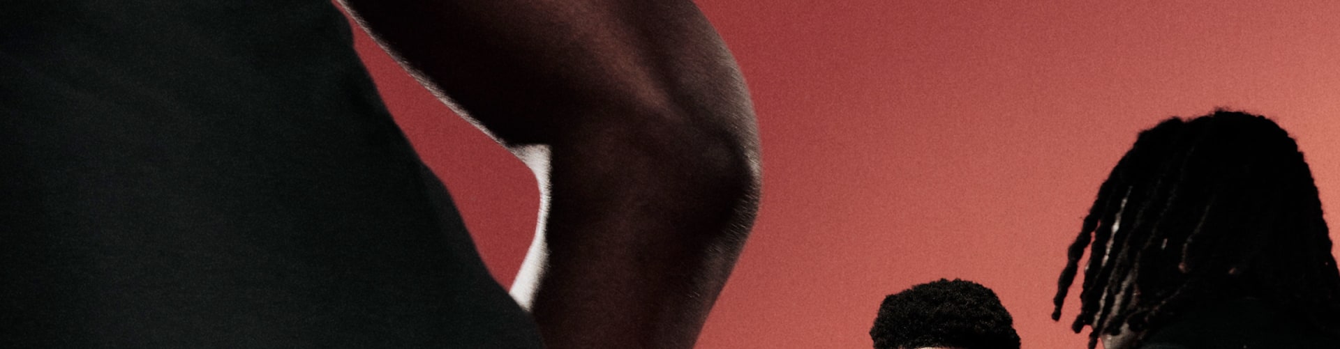 Anthony Edwards dribbles a basketball on an indoor court, wearing a white adidas t-shirt and black adidas shorts. Two defenders in black adidas outfits face him.