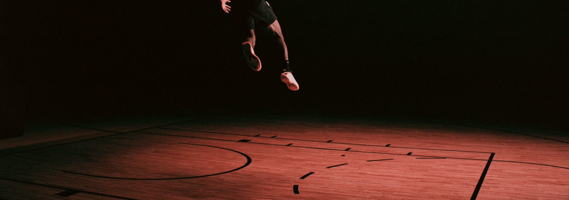 Anthony Edwards dunks a basketball on an indoor court, wearing a white adidas t-shirt, black adidas shorts and the Anthony Edwards 2 basketball sneaker.