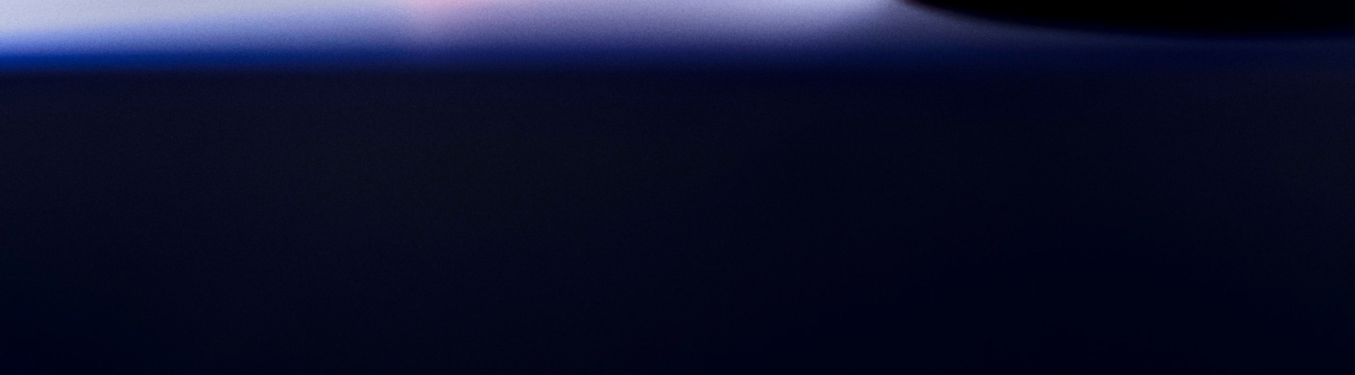 A dark, moody background with a gradient of deep blues and purples, creating a sense of depth and mystery.